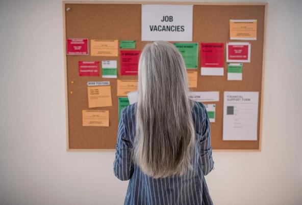 Woman looking at jobs board on wall