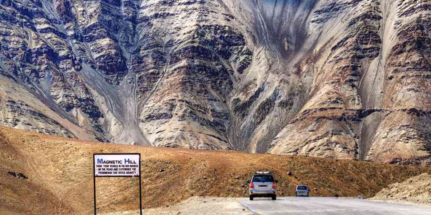 Magnetic Hill road surrounded by barren mountains in Ladakh