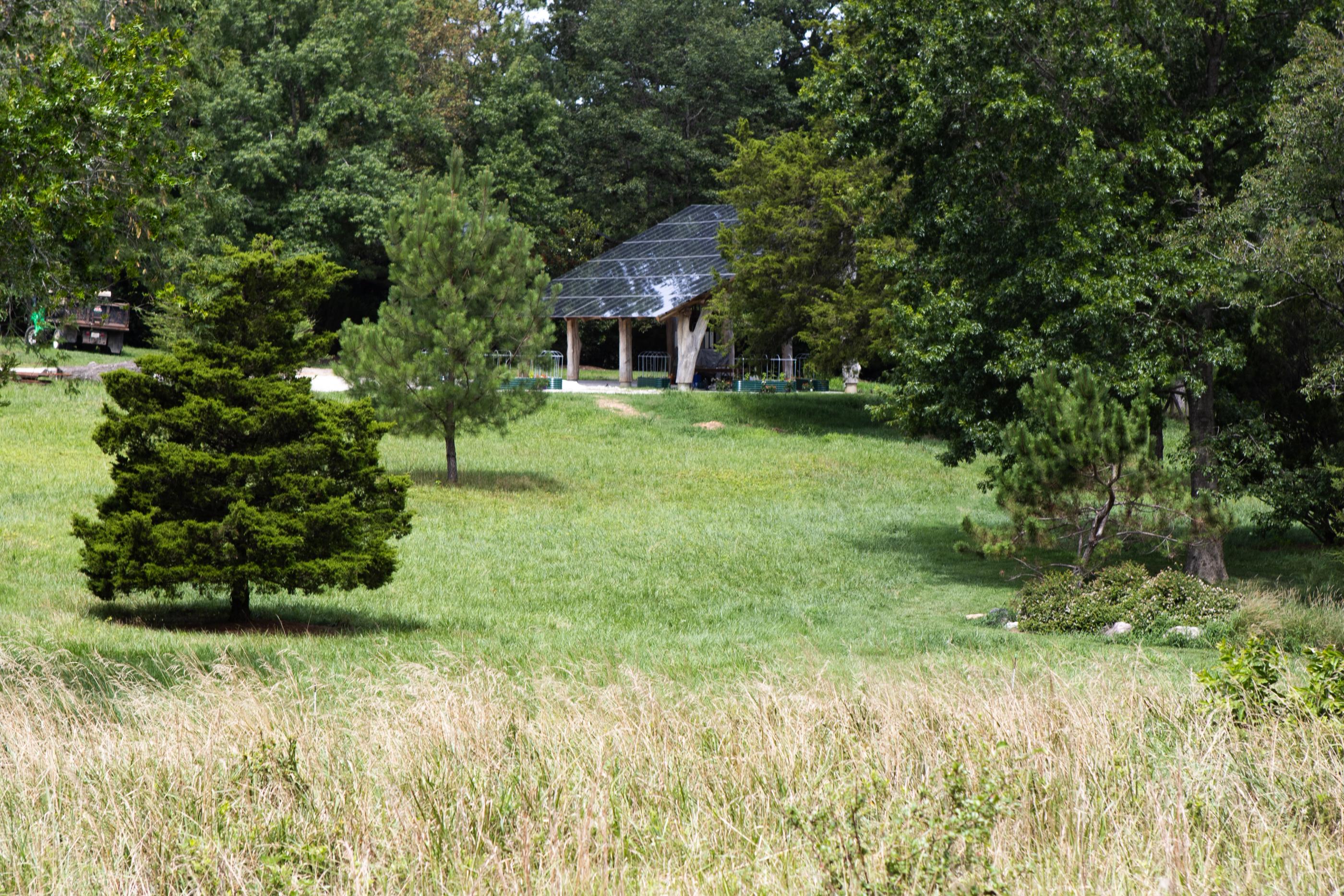 A solar panel sits off in the distance with a field in the foreground.