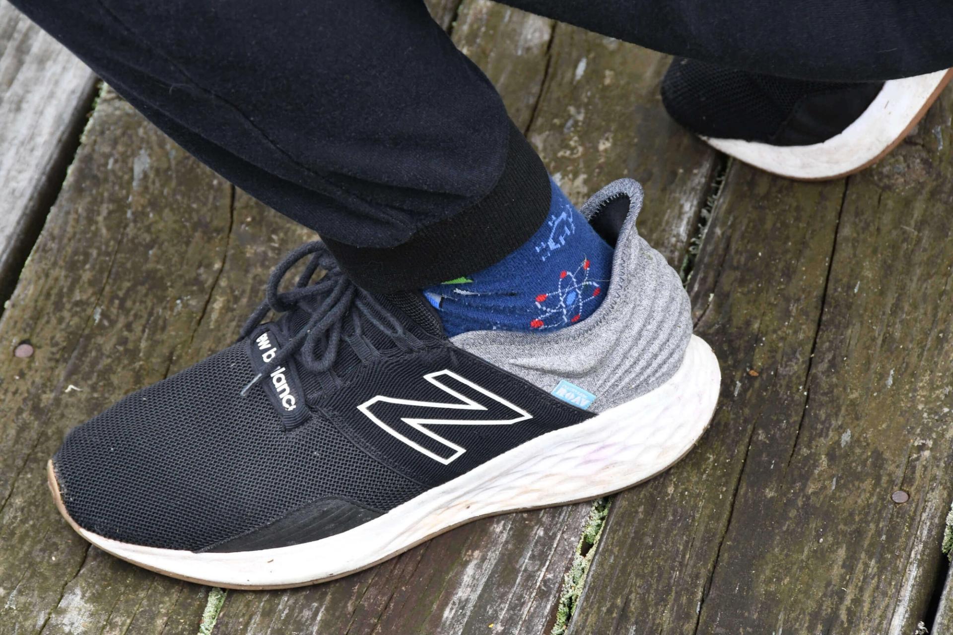 A close up photo of a researcher's socks that show a water molecular model.
