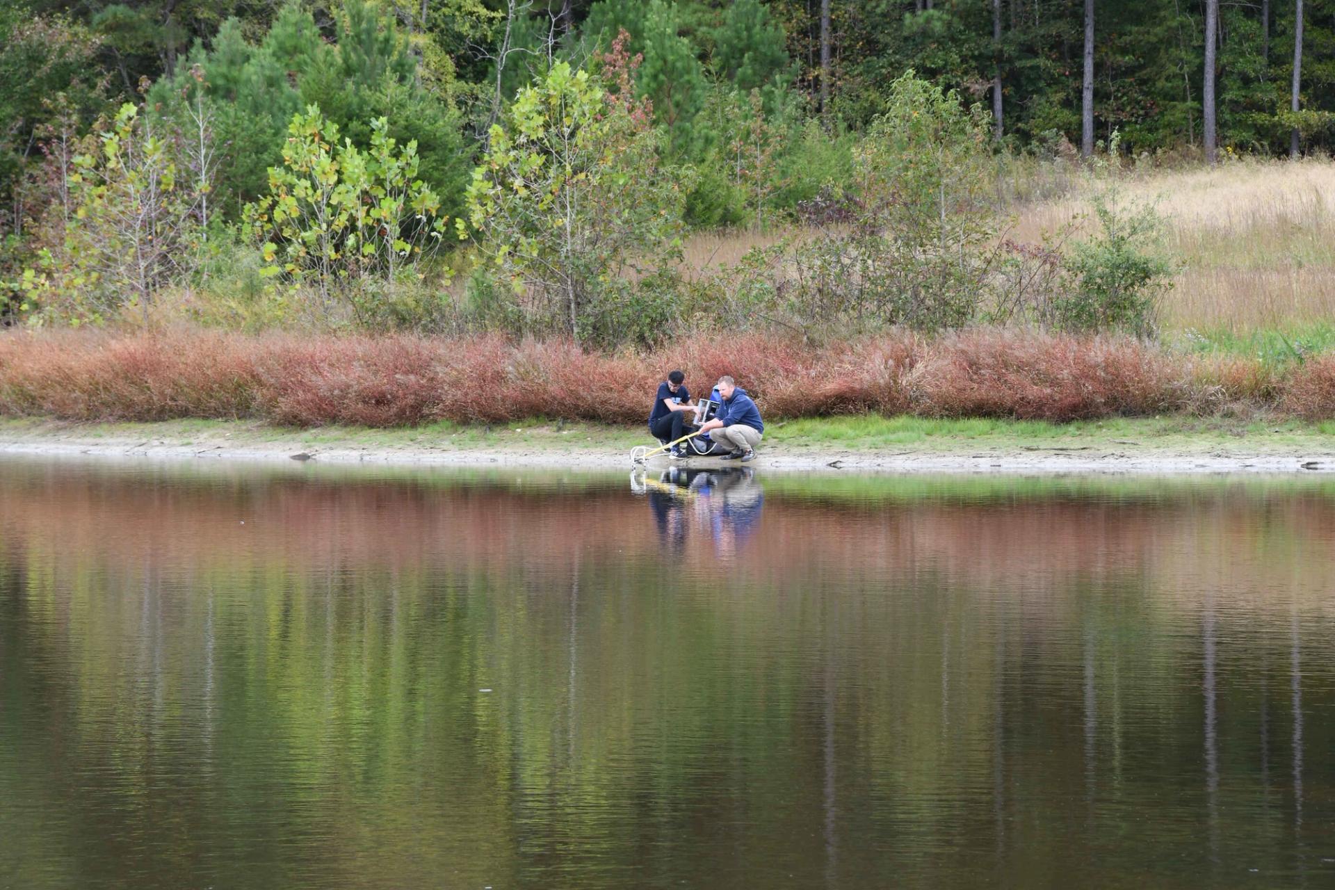 Researchers get a sample from the water's edge.