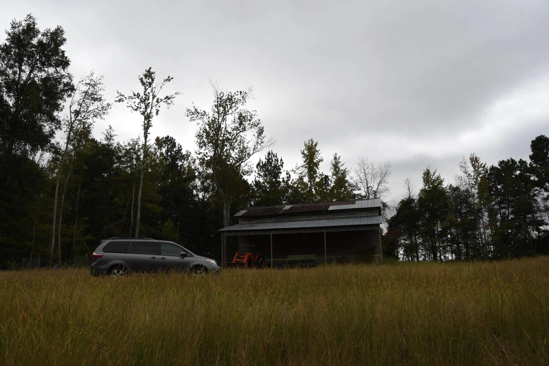 A van parked in a windswept field.
