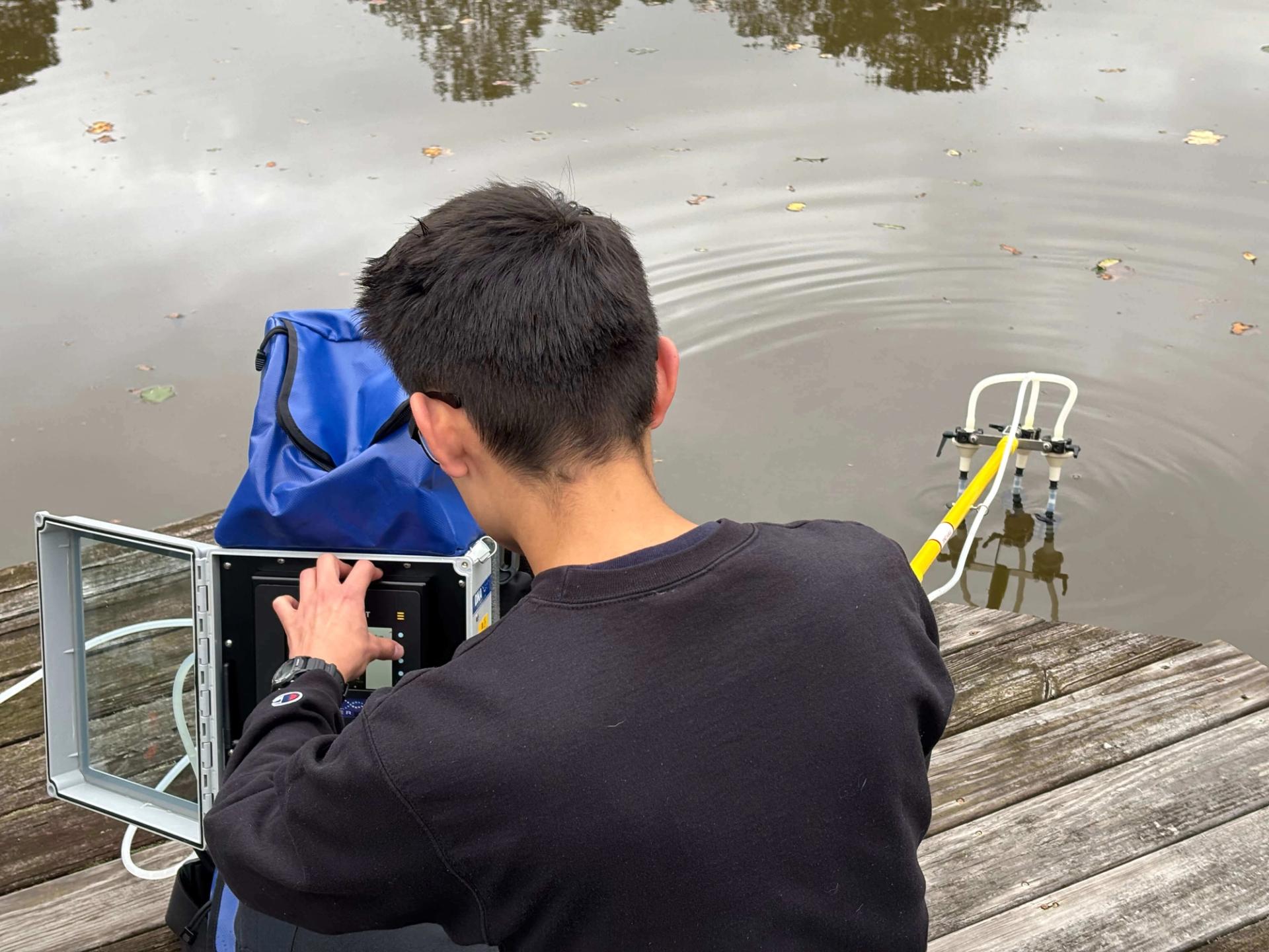 A researcher pushes a button on their water sampling equipement.