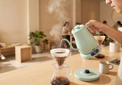 Thermomètre de précision mesurant la température de l'eau dans une bouilloire col de cygne pour la préparation du café, affichant la plage de température optimale pour l'extraction