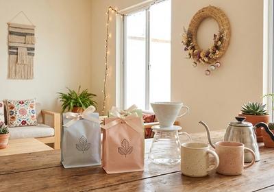 Coffret cadeau café joliment emballé avec des grains artisanaux, du matériel d'infusion et des décorations de fête