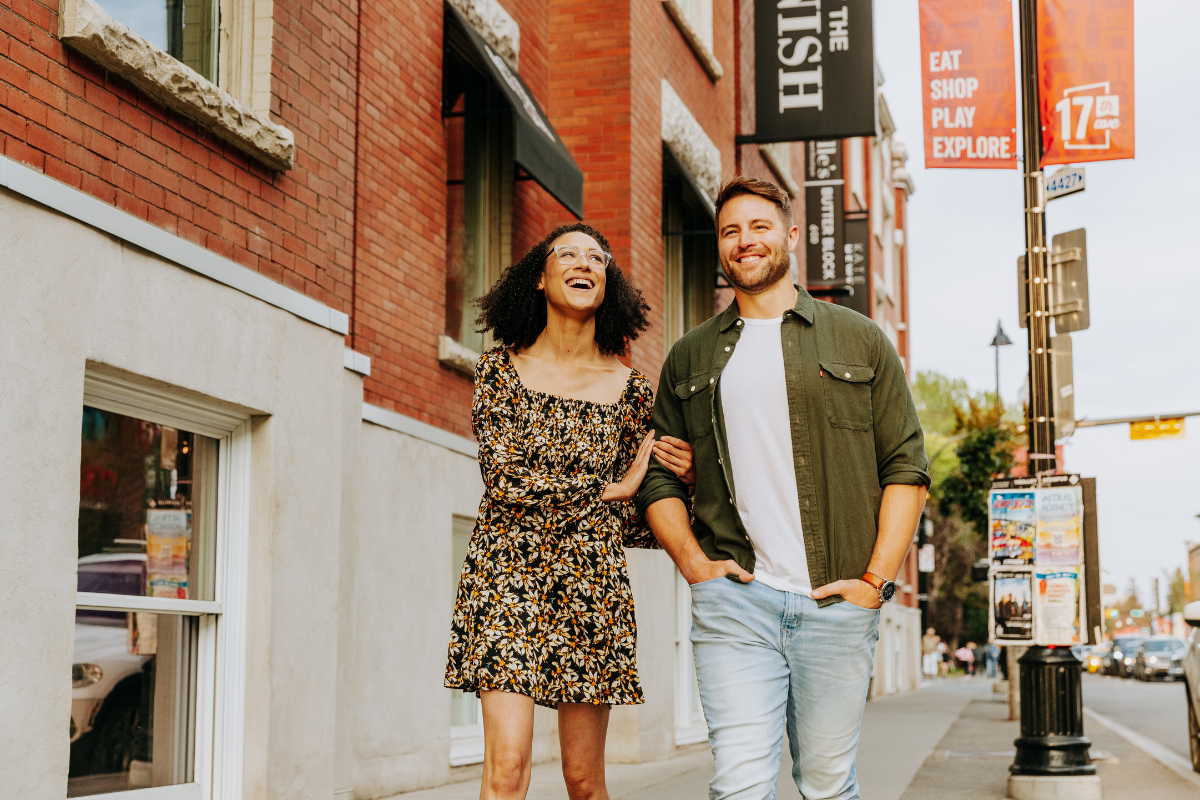A man and woman walk arm in arm down Calgary's 17th Avenue South.