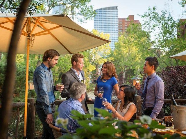 Group of business people enjoying drinks on a patio in Prince's Island Park.