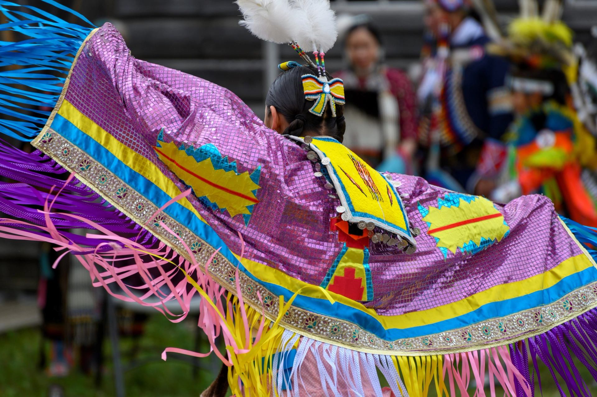 A woman in traditional Indigenous dance regalia at Fort Whoop-Up.