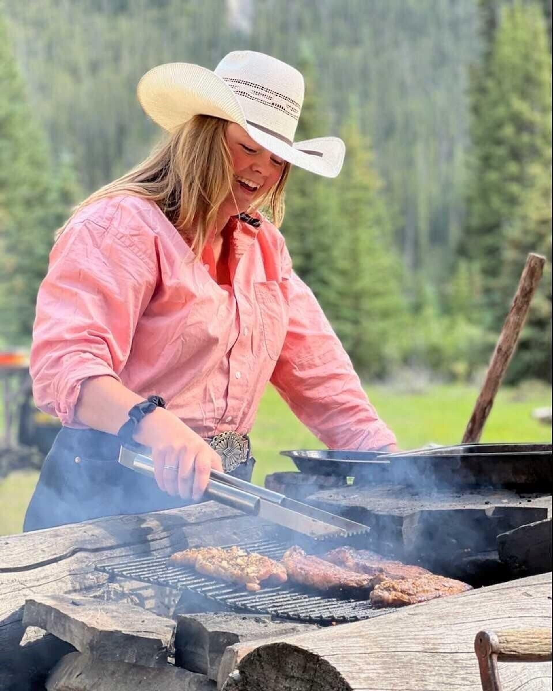 Woman grilling steak in the backcountry