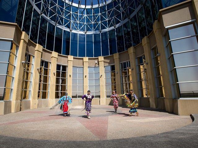 Siksika Blackfoot dancers in front of the Blackfoot Crossing Historical Park Interpretive Centre.