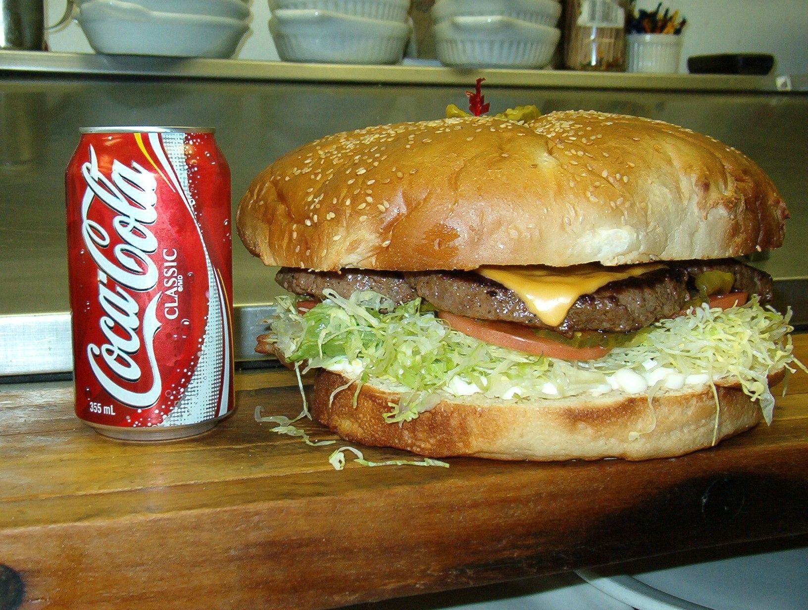A huge hamburger and a can of cola