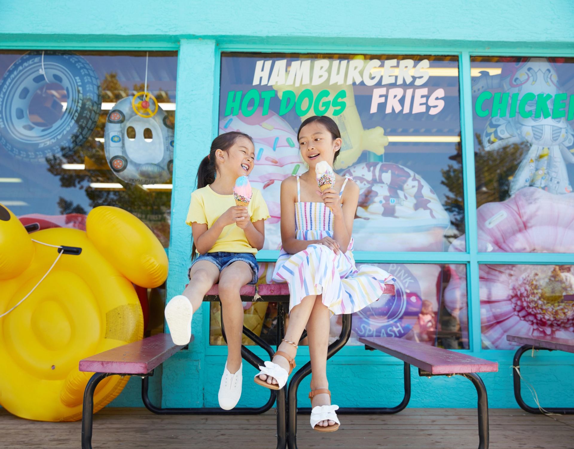 Two young girls sit outside a retro diner enjoying ice cream cones in Sylvan Lake.