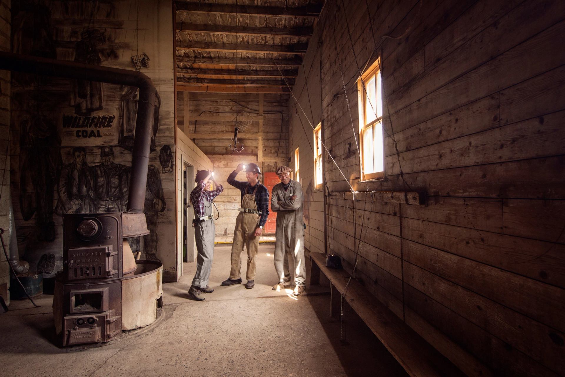 Couple wearing mining hats and exploring Atlas Coal Mine with a guide.