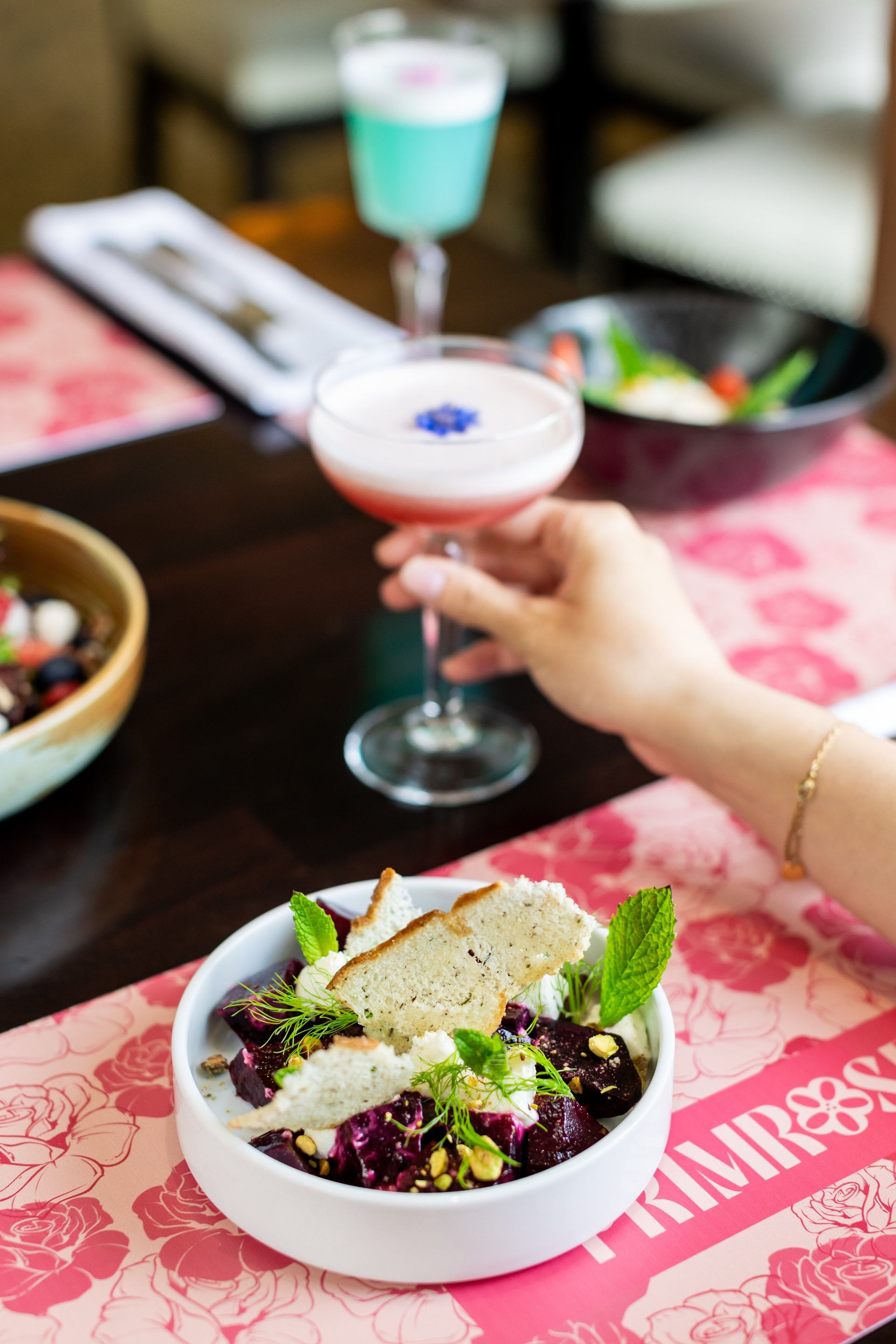 A cocktail and salad in Primrose at The Rimrock Banff