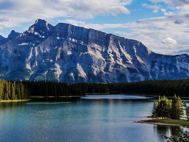 Scenic shot of Johnson Lake set against a majestic mountain range in Banff National Park.