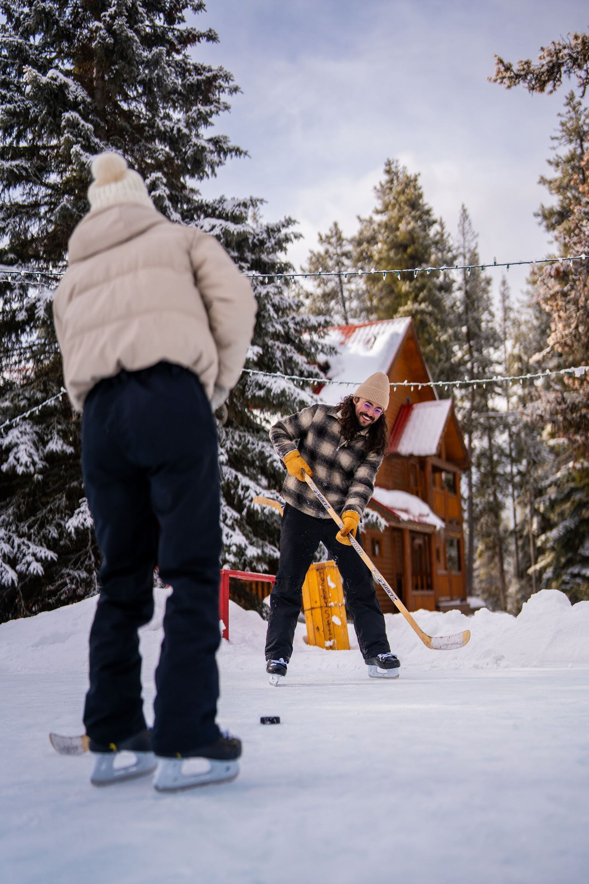Couple playing hockey at Baker Creek Cabins.