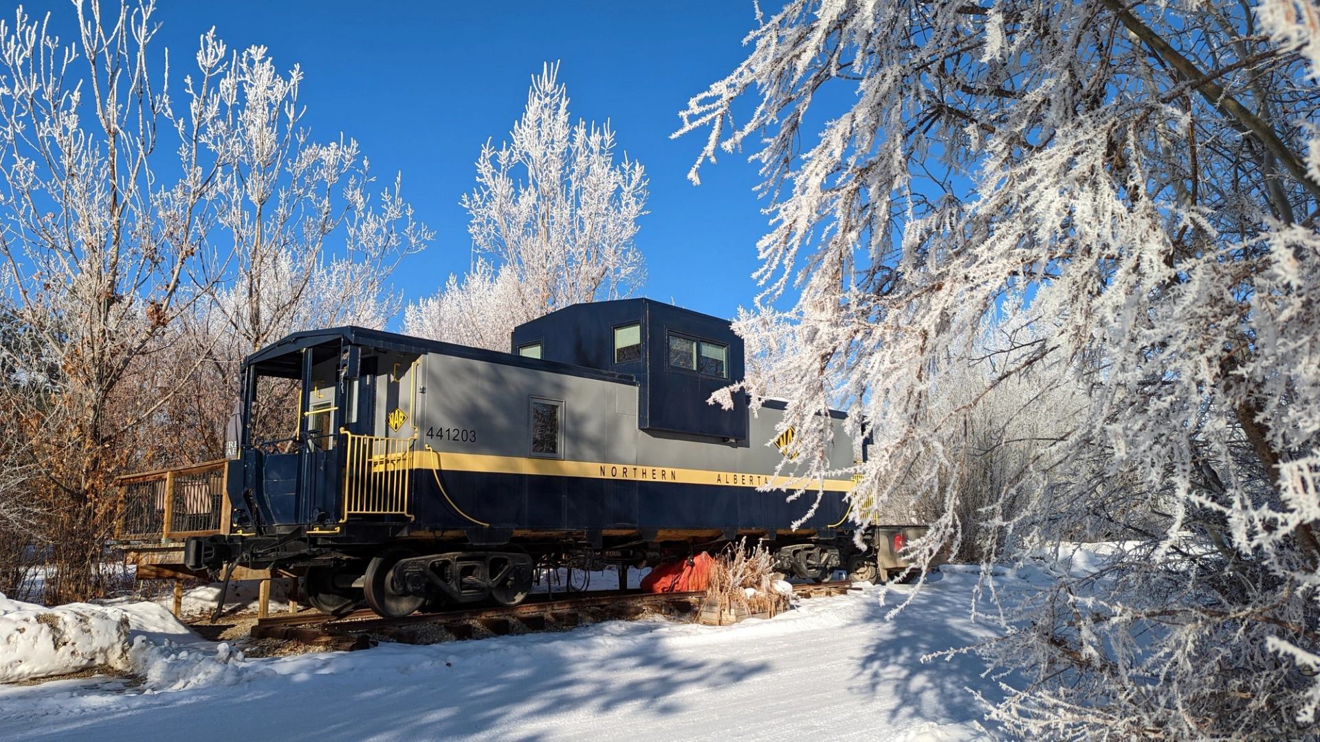 Exterior of an Aspen Crossing Caboose Cabin during winter.