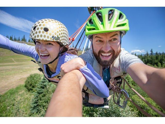 A man and woman on a tandem zipline.