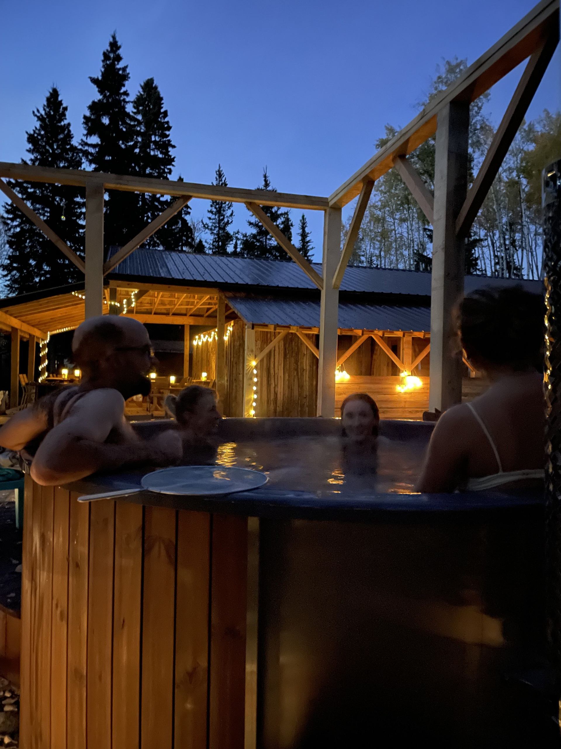 Two people enjoying the wood fired hot tub.