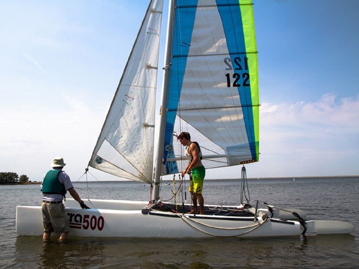 Two people with a Catamaran in the lake.