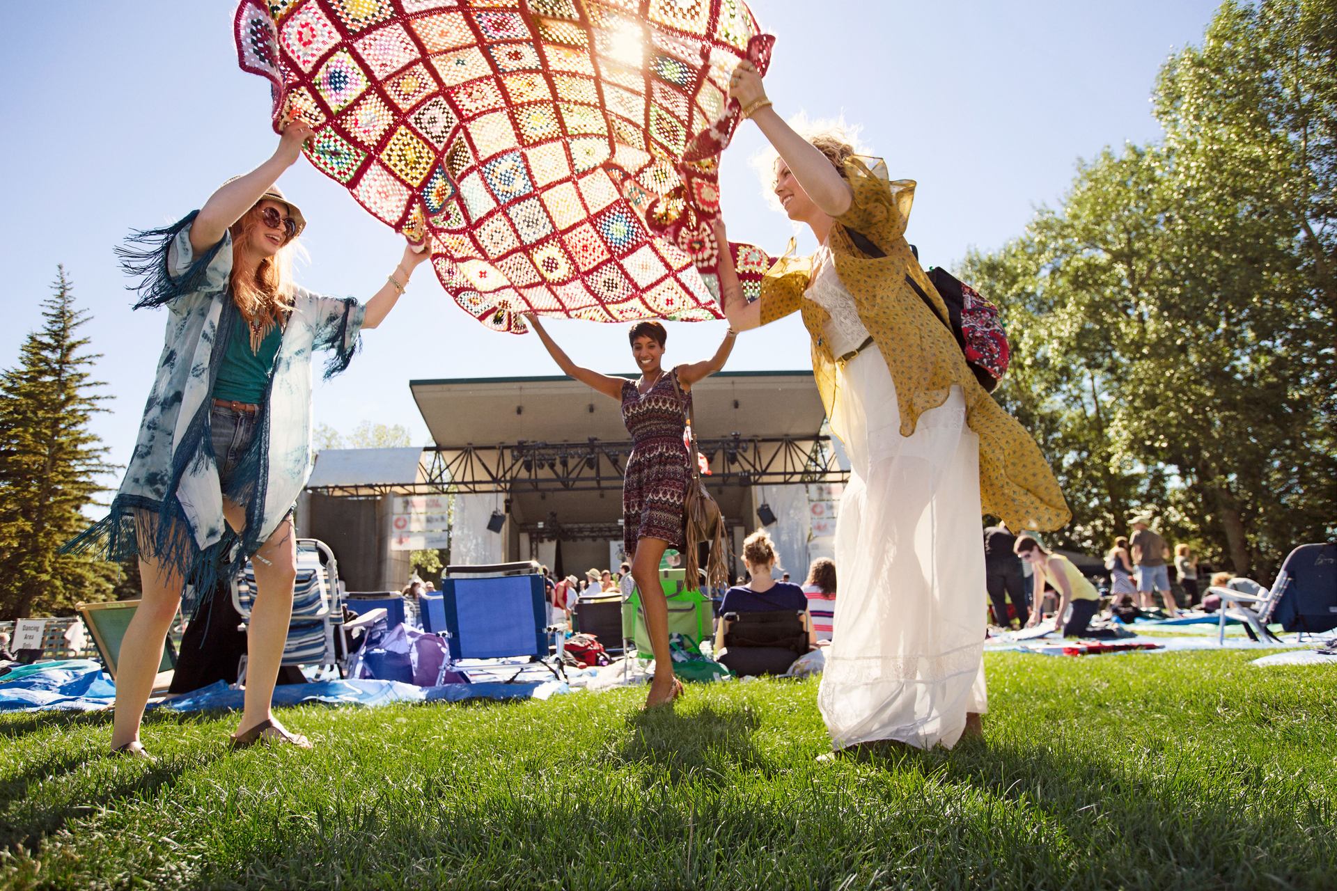 People placing a blanket down at the Calgary Folk Festival at Prince's Island Park.