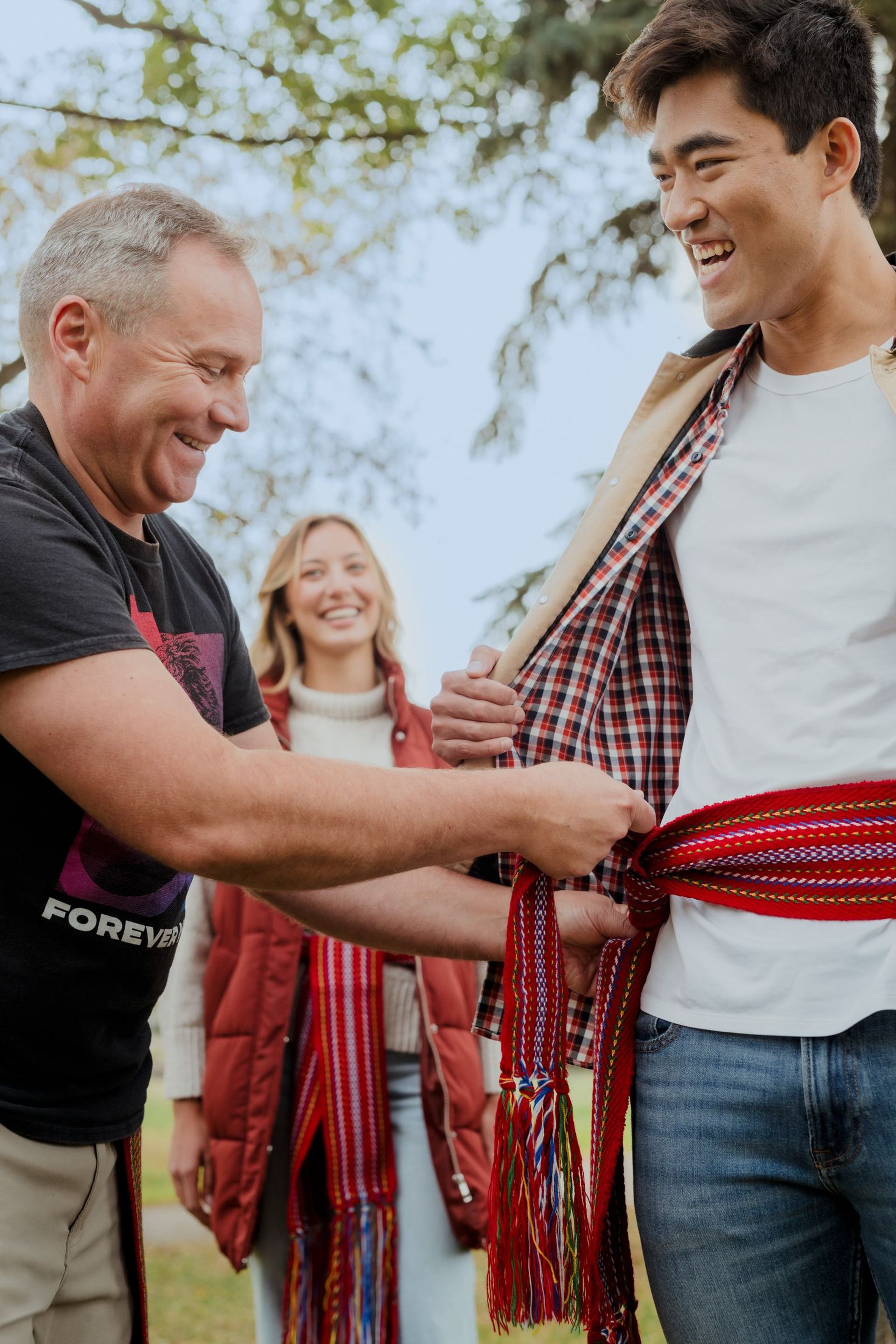 Indigenous Guide putting a Métis sash on a guest (Geo-Explorer) in making them an honorary Métis at the beginning of the geo-experience.
