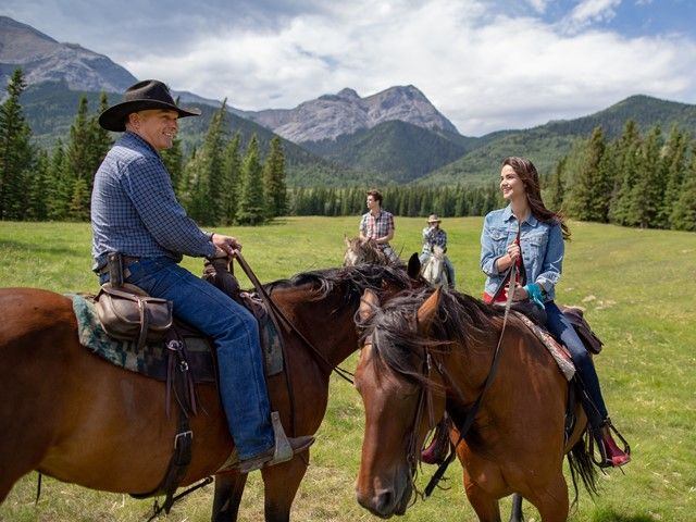 A family riding horses in a field