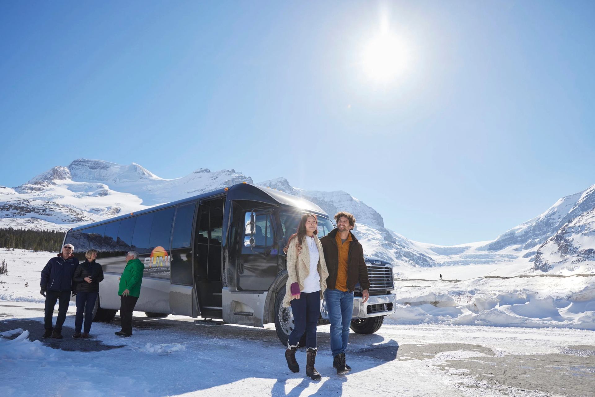 A group of people outside the tour bus.