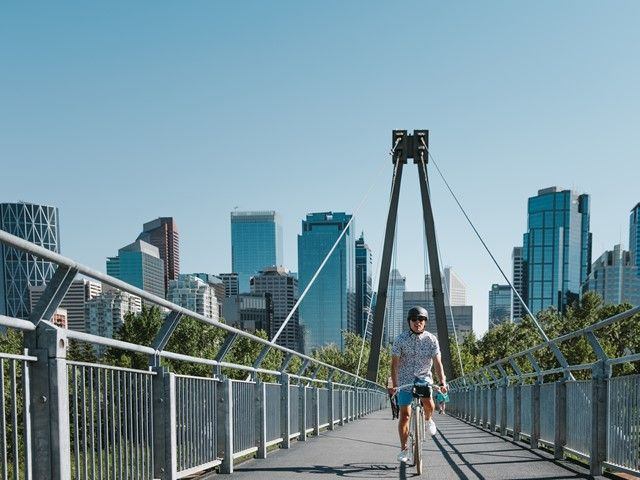 Person riding over a bridge in Prince's Island Park.
