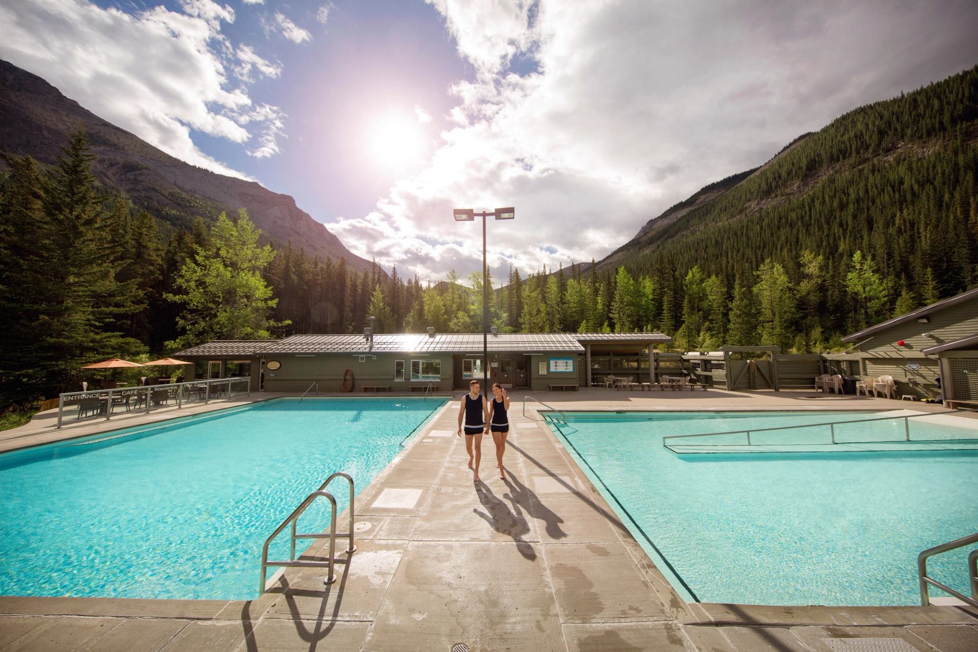 A couple walking on the pool deck at Miette Hot Springs.