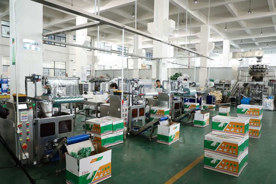 IFAN production floor with packing lines and stacked IFAN-branded fitting cartons awaiting despatch