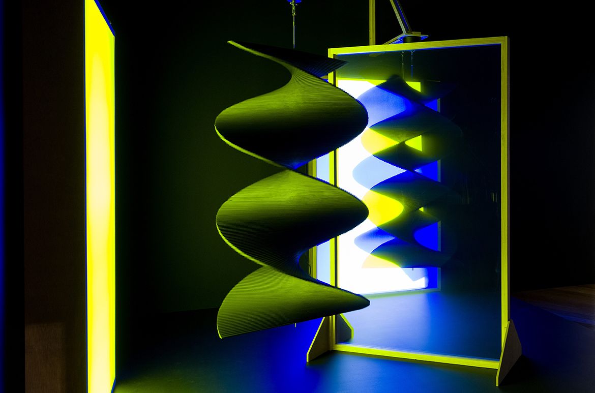 Taree Mackenzie, Australia b.1980 / Pepper’s ghost, wind turners, blue and yellow 2018 / Acrylic, foam core, steel, reflective tinting, LEDs, motor, paint, wood, vinyl / Reflective screen: 200 x 120 x 7cm; hanging sculpture: 150 x 80 x 80cm; brackets: 120 x 120cm / Purchased 2020 with funds from the Future Collective through the QAGOMA Foundation / Collection: Queensland Art Gallery | Gallery of Modern Art / © Taree Mackenzie