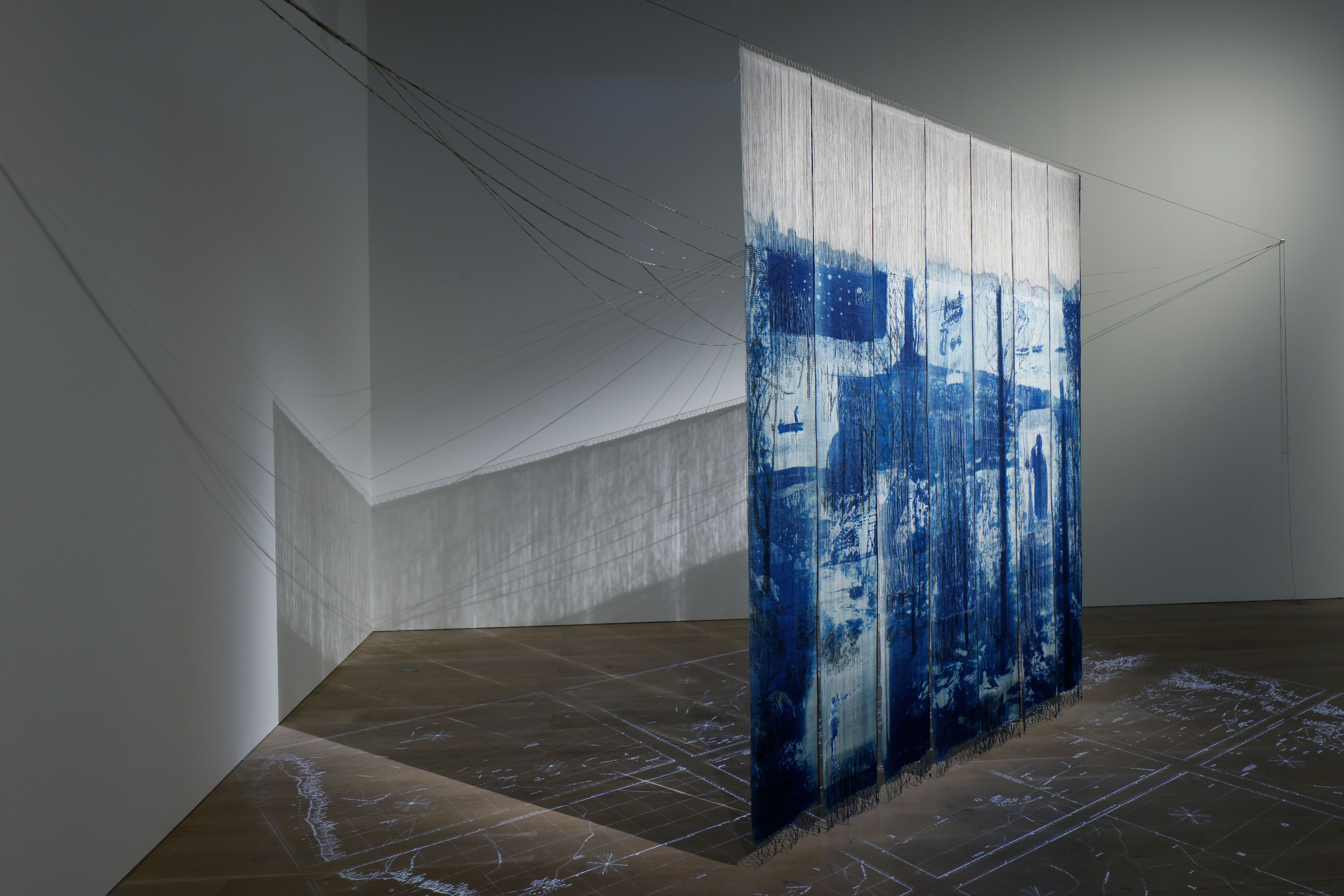 Haji Oh / Osaka, Japan, b.1976 / Seabird Habitats 2022 / Linen (plainwoven, warp-faced, pick-up patterned, four-selvedge cloth), lead, hook, slide projection / Seven panels: 300 x 41cm (each); 300 x 287cm (installed); floor projection 550 x 400cm; installed dimensions variable / Courtesy: The artist / Proposed for the Queensland Art Gallery | Gallery of Modern Art Collection