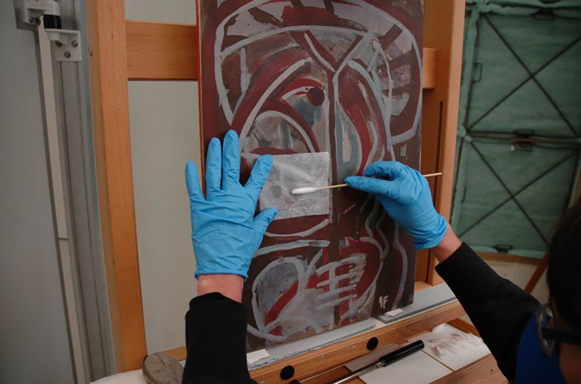 During the varnish removal process, solvents are applied through Japanese tissue to remove the varnish while protecting the paint surface.