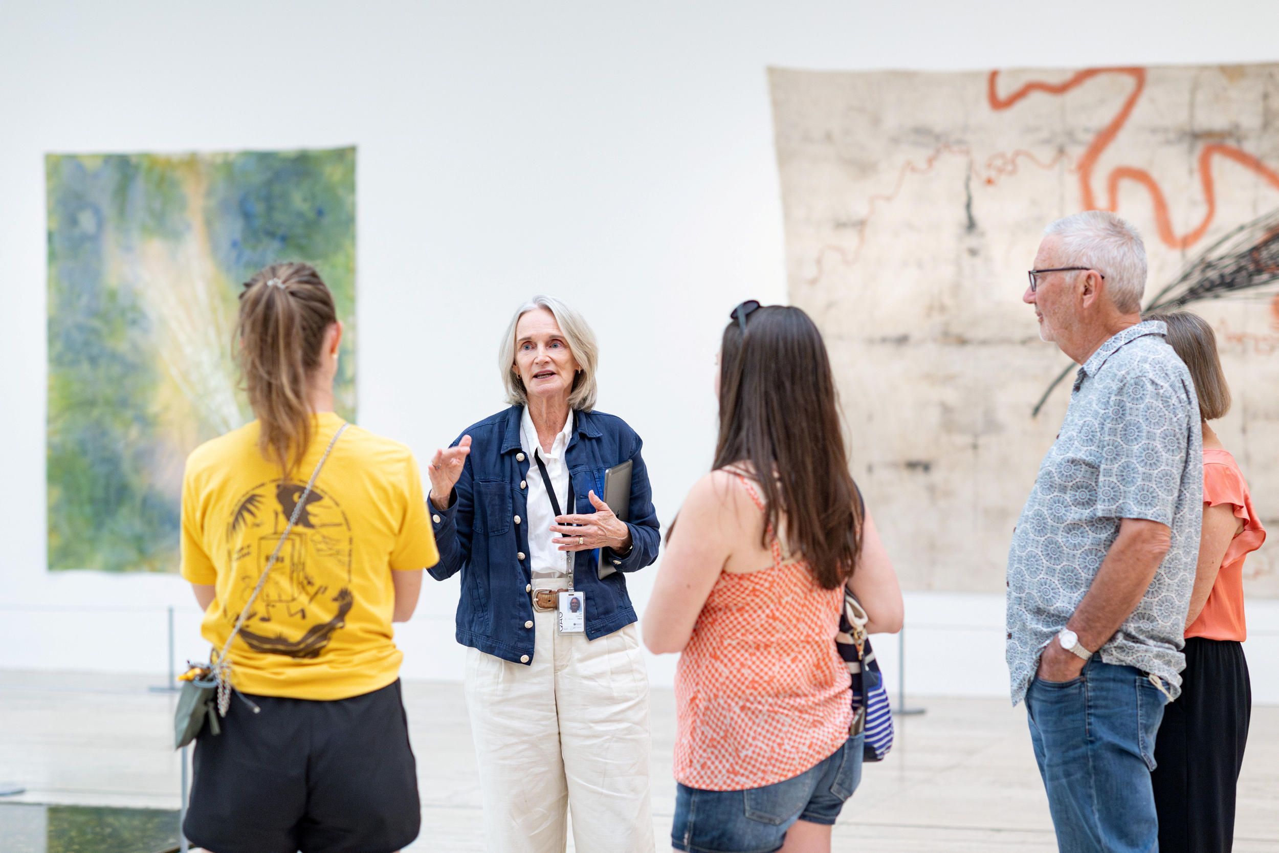 A Volunteer Guide engages visitors on a tour at the Queensland Art Gallery (QAG). Photography by Chloe Callistemon | QAGOMA