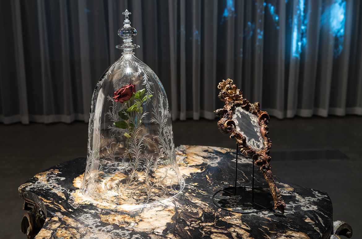 Bill Condon (director), United States; Sarah Greenwood (designer), England / From Beauty and the Beast 2017; Cast: Emma Watson, Dan Stevens, Luke Evans / / ‘Rose in a bell jar’; Glass, plastic, wire; 61 x 36 x 36cm / ‘Mirror’; Mirror, plastic, paint; 45.7 x 21.6 x 5cm / ‘Table’; Wood, marble, artificial snow, resin, plastic; 76.2 x 101.6 x 101.6cm / Courtesy: The Walt Disney Company / © Disney Enterprises, Inc. All Rights Reserved / Photograph: N Umek © QAGOMA