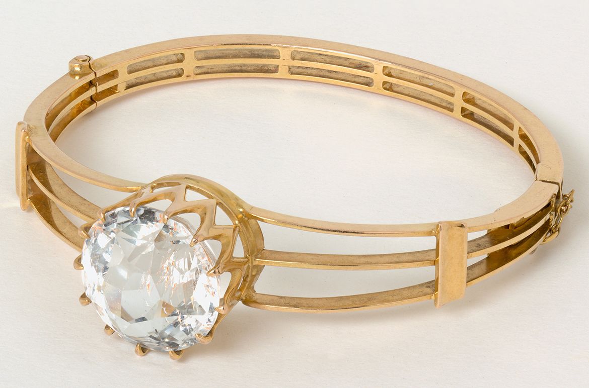 Mackay and Co. Australia active 1884–1982 / Gold and topaz bangle c.1900 / 18k yellow gold in hinged triple-bar design, set with a large central facetted topaz, approx. 22.5cts / 5.5cm (inside diam.); 24 grams (weight) / Purchased 2020. Queensland Art Gallery | Gallery of Modern Art Foundation / Collection: Queensland Art Gallery | Gallery of Modern Art