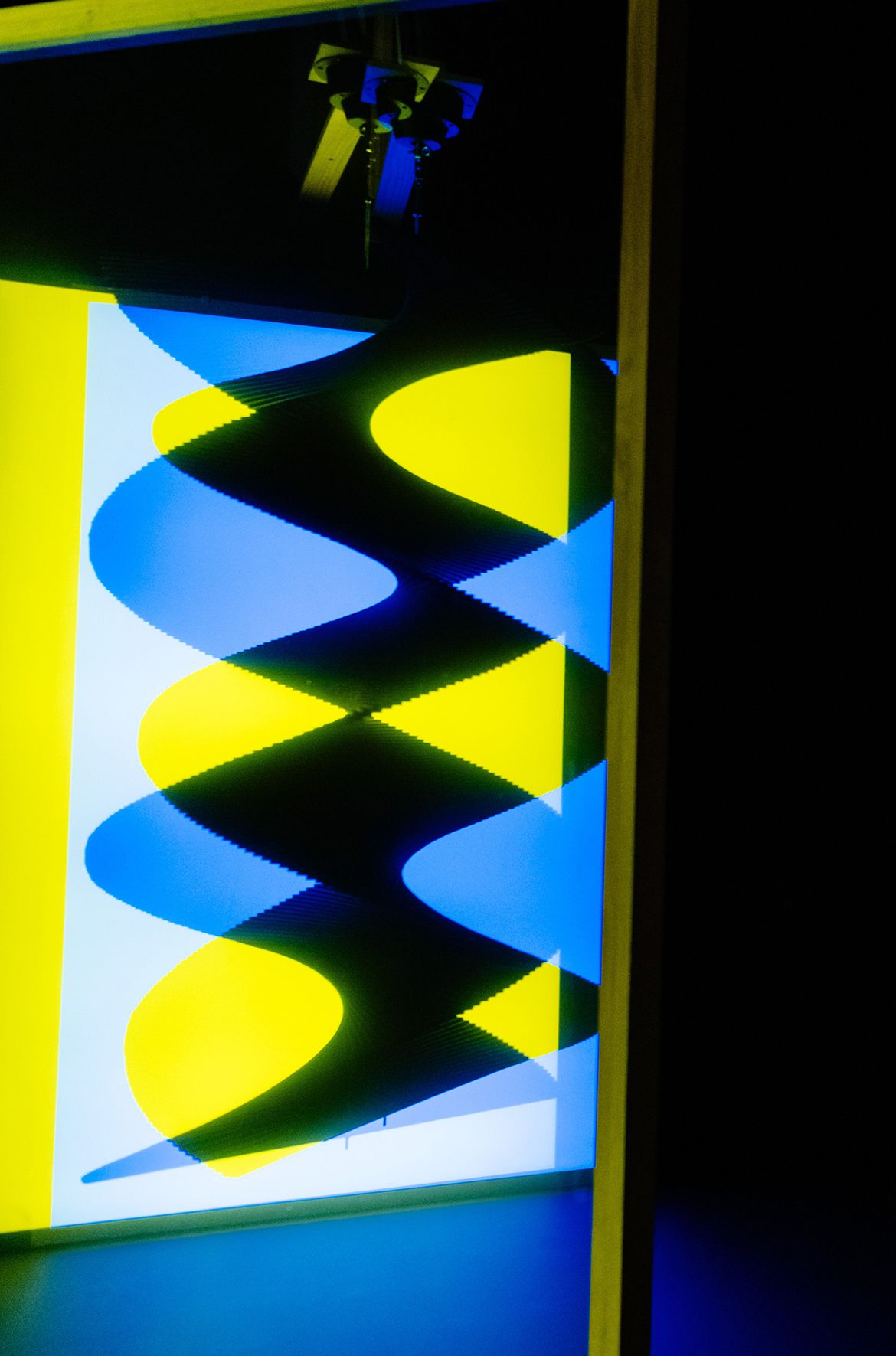 Taree Mackenzie, Australia b.1980 / Pepper’s ghost, wind turners, blue and yellow 2018 / Acrylic, foam core, steel, reflective tinting, LEDs, motor, paint, wood, vinyl / Reflective screen: 200 x 120 x 7cm; hanging sculpture: 150 x 80 x 80cm; brackets: 120 x 120cm / Purchased 2020 with funds from the Future Collective through the QAGOMA Foundation / Collection: Queensland Art Gallery | Gallery of Modern Art / © Taree Mackenzie