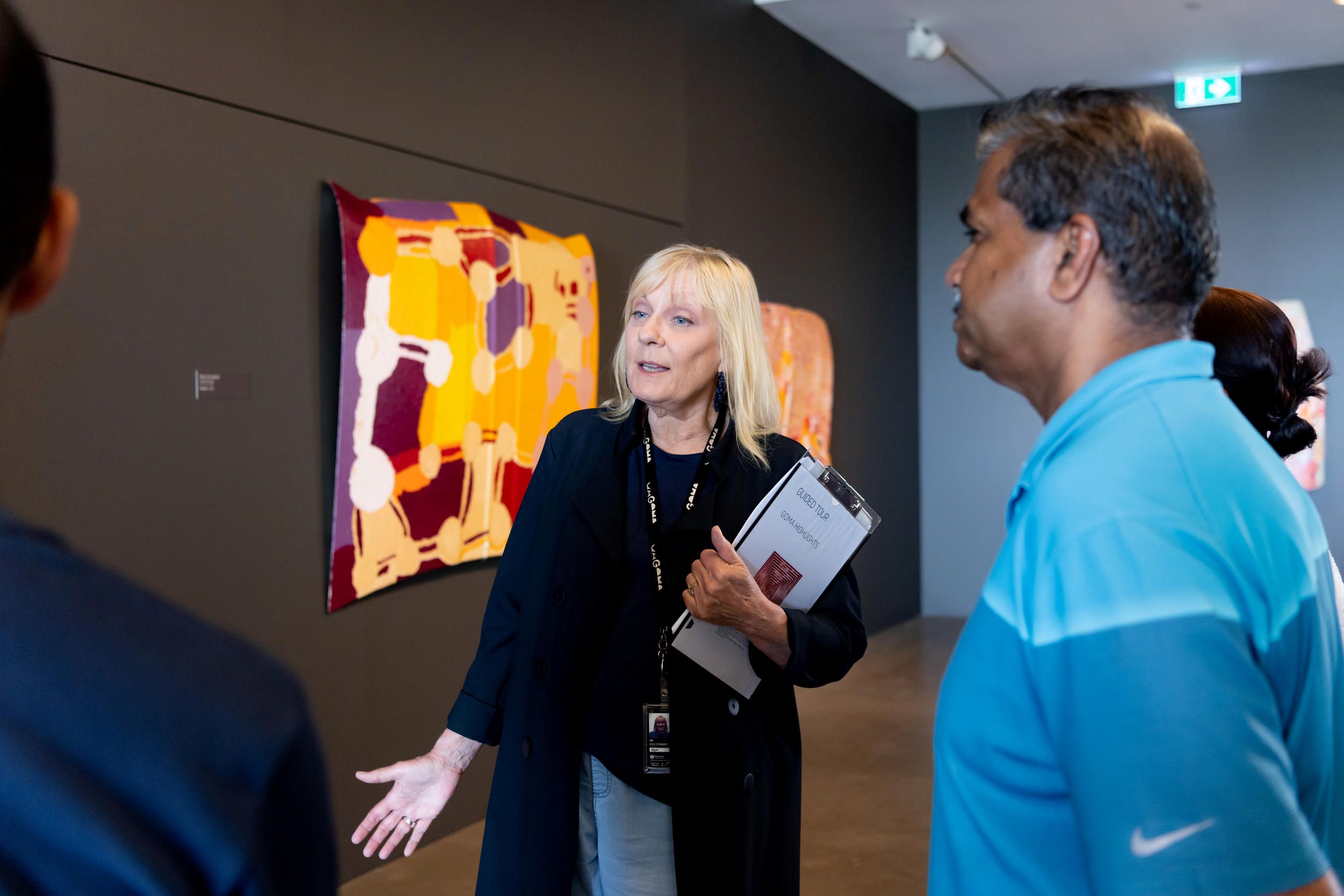 A Volunteer Guide engages visitors on a tour at the Queensland Art Gallery. Photography by Chloe Callistemon | QAGOMA