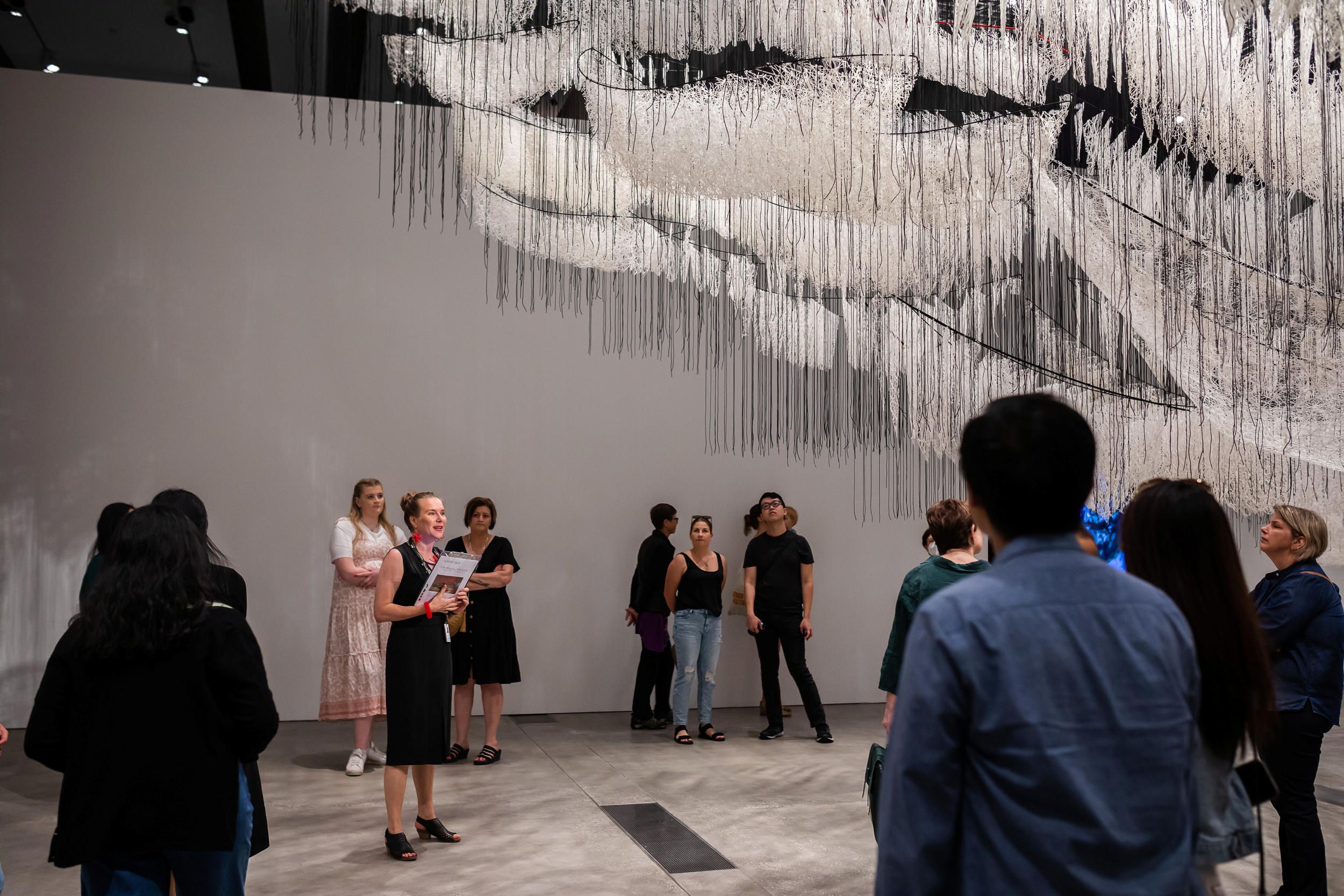 A Volunteer Guide engages visitors on a tour at the Gallery Of Modern Art. Photography by Katie Bennett | QAGOMA