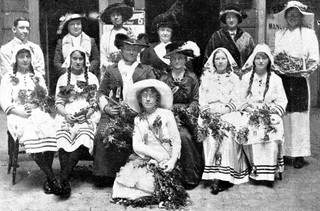 Daphne Mayo (dressed as a wattle maid, the centre foreground) participating in Wattle Day celebrations in Brisbane, 1914. Mayo was awarded the Wattle Day travelling art fellowship in 1914, provided by the Queensland Wattle League / Courtesy: John Oxley Library, State Library of Queensland, Brisbane
