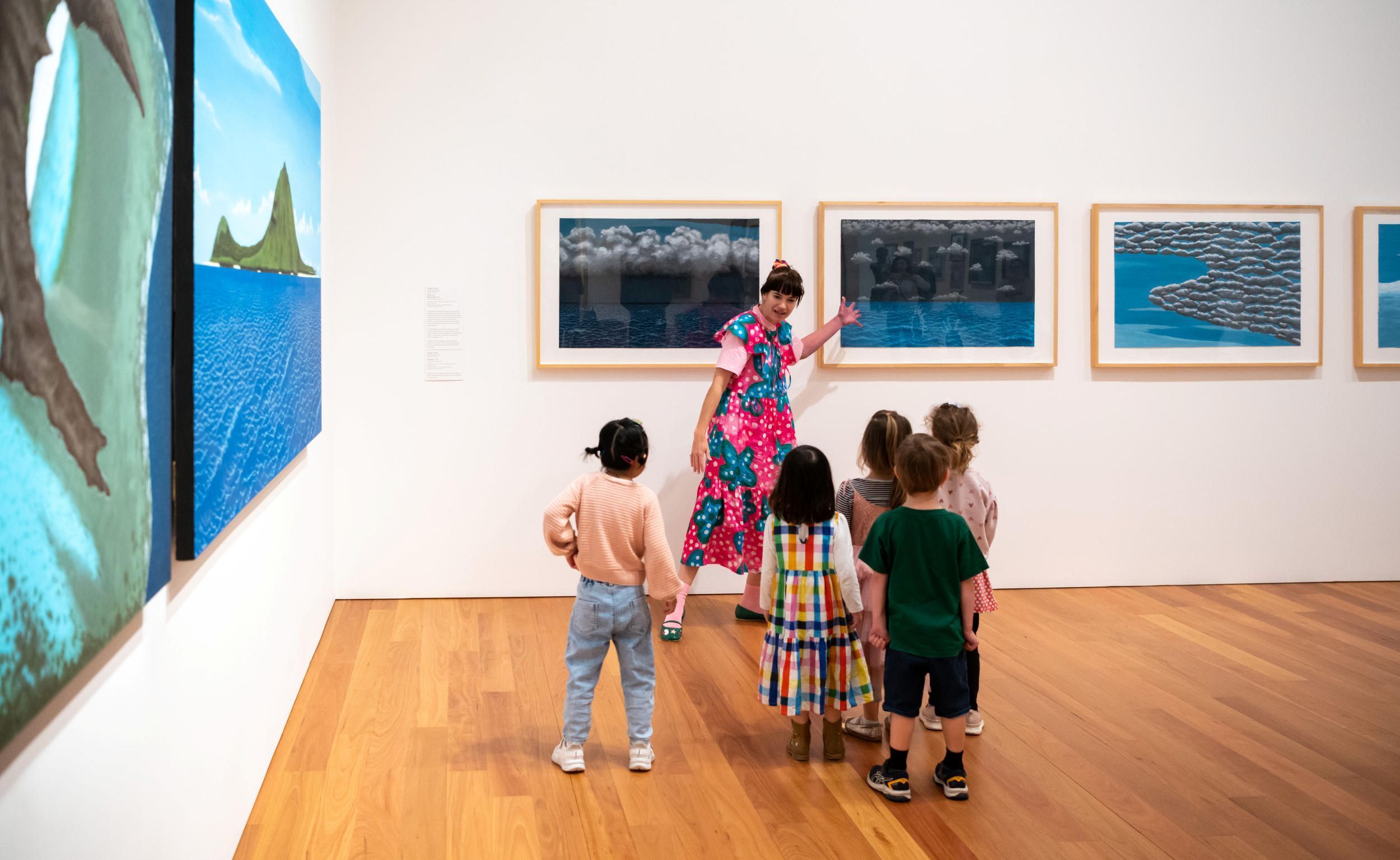 Participants at an Art Explorers program looking at the artworks Dauar 2014, Koob 2011, Deum Tepki 2011 and Ap gegur 2011 by Segar Passi. / Photograph: L Wilkes © QAGOMA