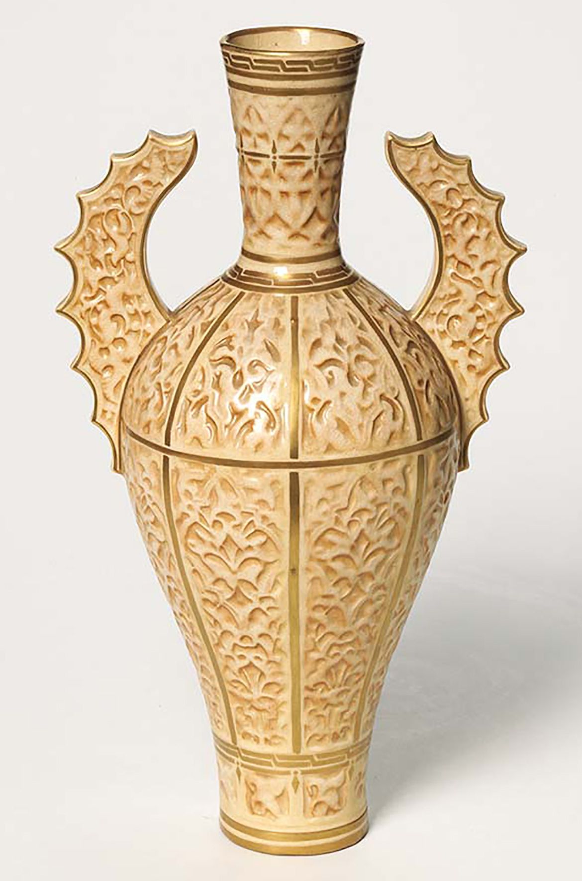 Doulton & Co. (Lambeth), England c.1858–1956 / Vase n.d. / Porcelain (parian) slip-cast moulded stylised foliage and decorated batwing
handles in the Persian style. Sprayed brown with gilt lines / 31.5 x 17 x 12cm / Acquired pre 1952 / Collection: Queensland Art Gallery | Gallery of Modern Art