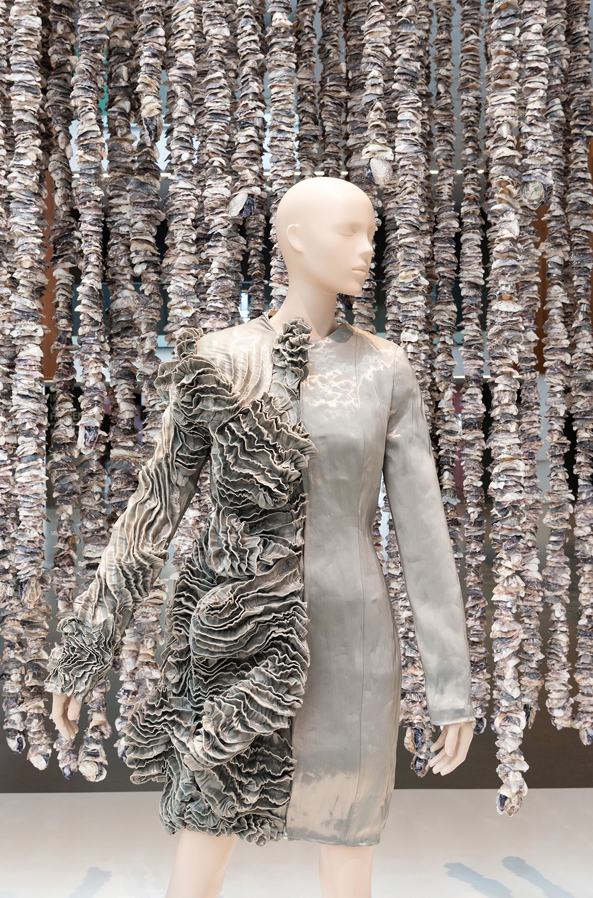 Megan Cope, Quandamooka people , Australia b.1982; Whispers Wall 2023; Oyster shells, steel cables; QAGOMA acknowledges the support of the Queensland Government through Arts Queensland in presenting this work; © Megan Cope; Courtesy: The artist and Milani Gallery, Brisbane / Iris van Herpen, Netherlands b.1984; Diploria coat, from the ‘Escapism’ collection 2011; Polyester–cotton-blend with metal thread; Collection: Groninger Museum, Netherlands; © Iris van Herpen atelier