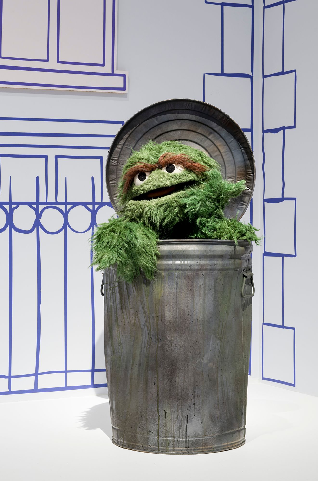 Installation view of 'Make, Believe, Magic: The Worlds of The Jim Henson Company', Gallery of Modern Art (GOMA), Brisbane, 2026, featuring 'Oscar the Grouch’ puppet with Trash Can from Sesame Street 1969–present / Collection: Sesame Workshop, New York / © 2026 Sesame Workshop. All Rights Reserved / Photograph: C Callistemon © QAGOMA