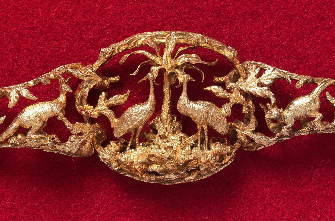 attrib. to HOGARTH, ERICHSEN & CO., Australia c.1854-65 (Manufacturer) / Julius Hogarth, Australia 1821-79 (Designer) / Conrad Erichsen, Australia c.1825-1903 (Maker) / Bracelet 1864 / Gold modelled in high relief with rusticated frames. The central section with an emu and brolga separated by a palm tree and subsidiary links depicting snake, kangaroo, possum and lizard / 3.8 x 17 x 1cm / Purchased 1987. QAG Foundation / Collection: Queensland Art Gallery | Gallery of Modern Art