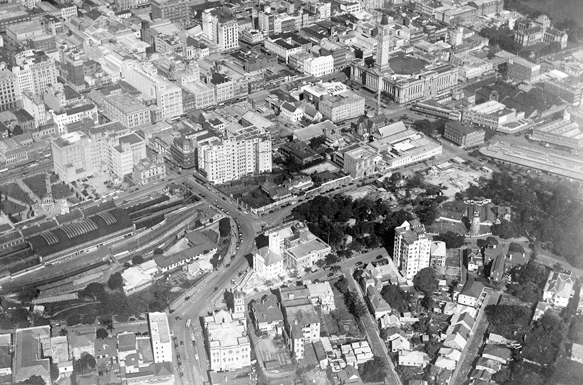 City block bounded by Anne, Edward, Turbot and Albert Streets showing all the landmarks illustrated in Wintry sunshine , and beginning of construction of the Dental hospital on the corner of Albert and Turbot Streets, 1938 / 3580266 / Courtesy: Queensland State Archives
