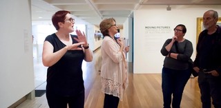 An Auslan interpreter accompanies a volunteer guide on a tour for d/Deaf visitors at the Gallery of Modern Art. Photograph: C. Callistemon