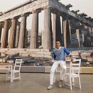 Michael Zavros in front of Acropolis now 2023 at ‘Michael Zavros: The Favourite’, Gallery of Modern Art, Brisbane / Photograph: David Kelly / © Michael Zavros