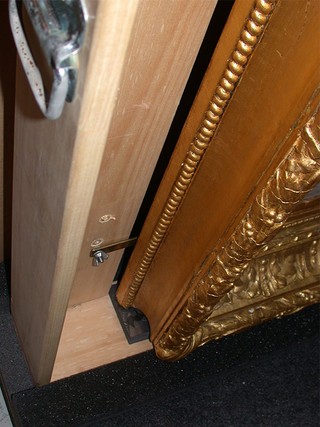 This delicate gilded frame is held into a handling frame using clips.